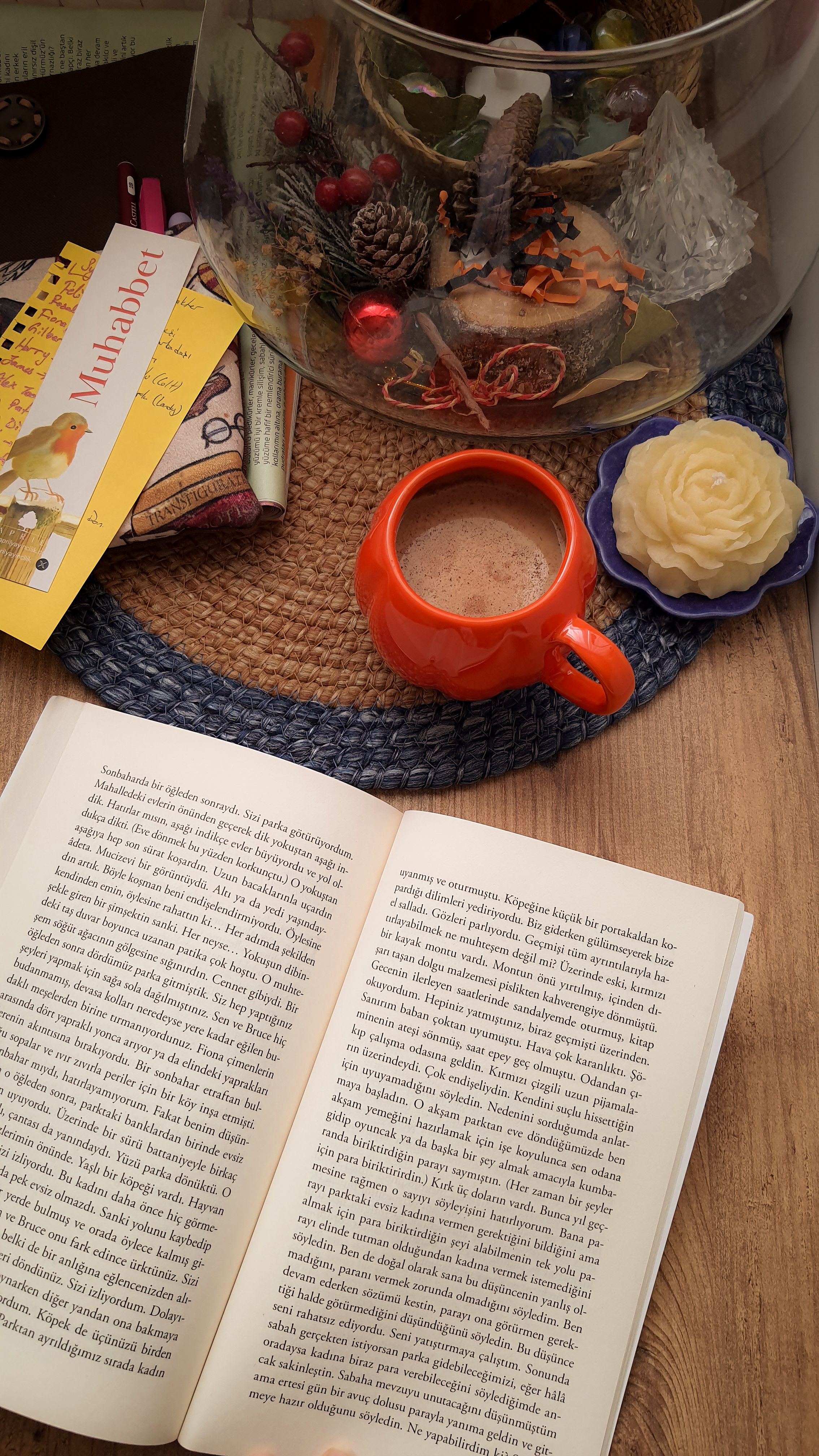 Top view of a cozy reading nook with books, a hot drink, and decorative elements.