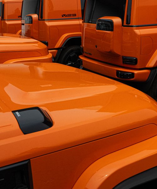 Free Close-up shot of bright orange SUVs parked, showcasing a modern automotive design aesthetic. Stock Photo
