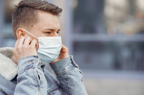 Man in Blue Denim Jacket Covering Her Face With Face Mask