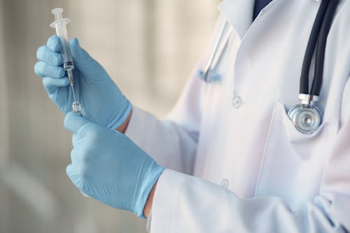 Free Person in White Long Sleeve Shirt Holding Injection Stock Photo