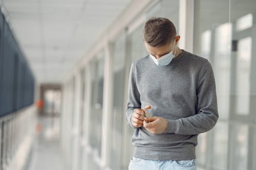 Man in Gray Sweater Holding Medicines