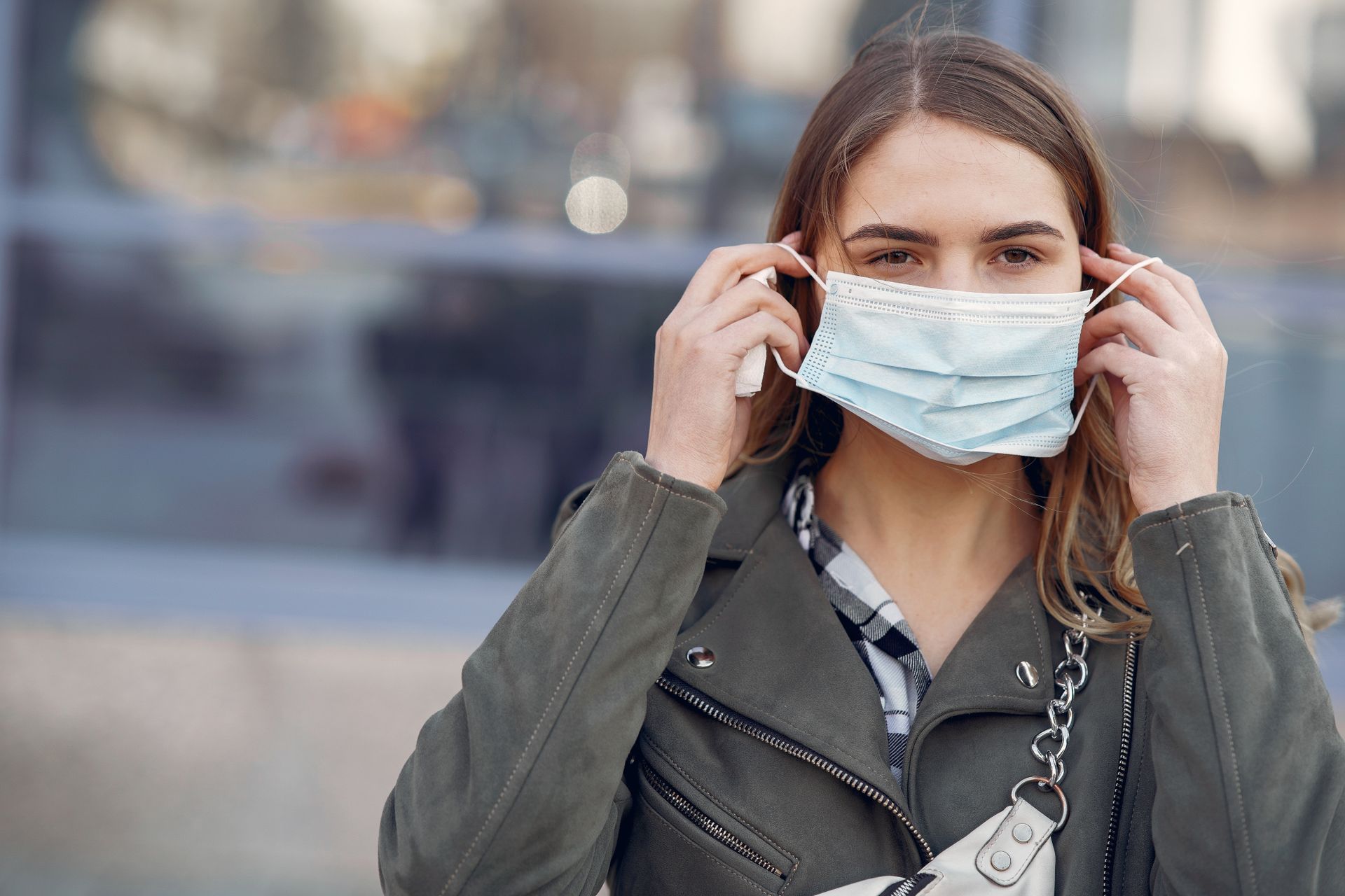 Young woman wearing a face mask outdoors for health protection.