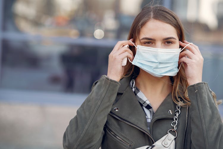 Woman In Gray Coat Wearing White Face Mask