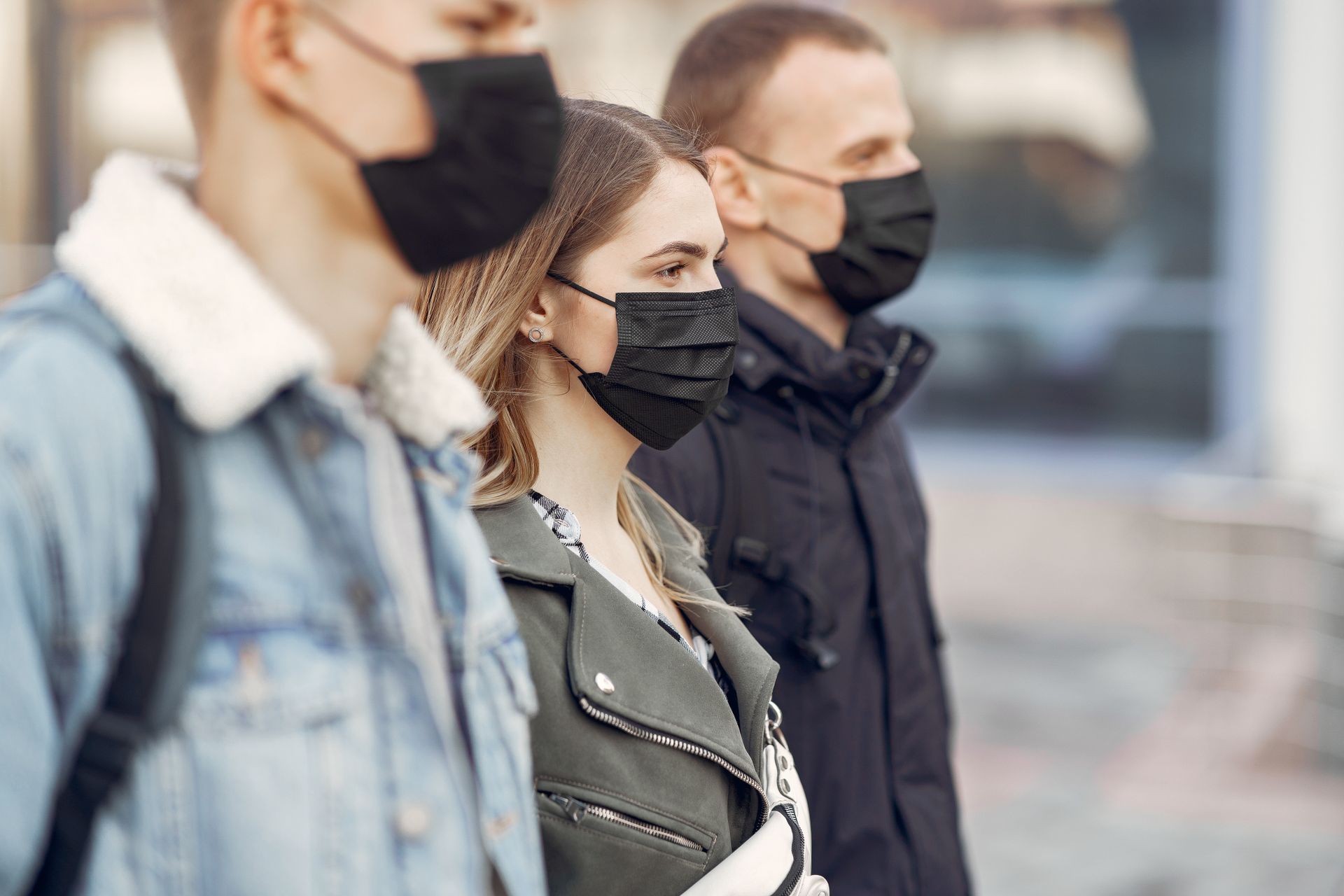 Group of adults wearing face masks outdoors showcasing COVID-19 prevention measures.