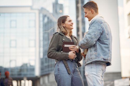 Free A young couple enjoys a pleasant conversation outdoors in an urban city environment. Stock Photo
