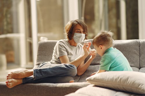 Woman with Face Mask Playing with Her Son