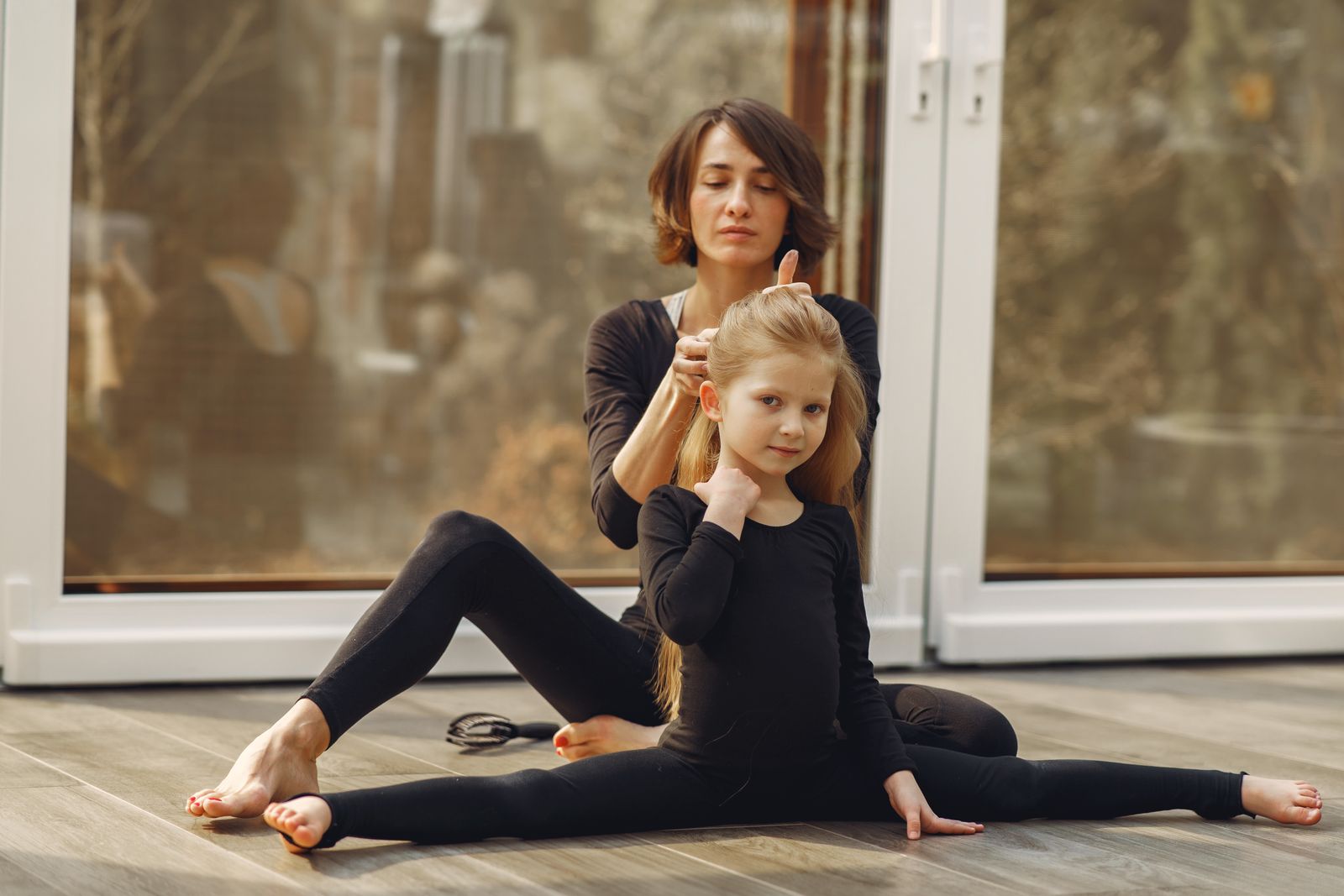 A parent and child stretching together during a yoga session at home