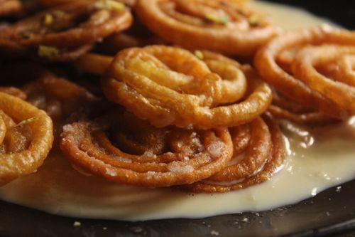 Free Close-up of traditional Indian jalebi dessert served with creamy condensed milk. Stock Photo