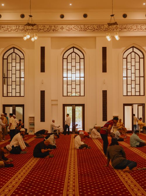 Free Muslim worshippers gathered in Shah Alam mosque interior showcasing Islamic architecture. Stock Photo