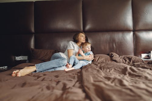 Free Mother and Son Lying on Brown Bed Stock Photo