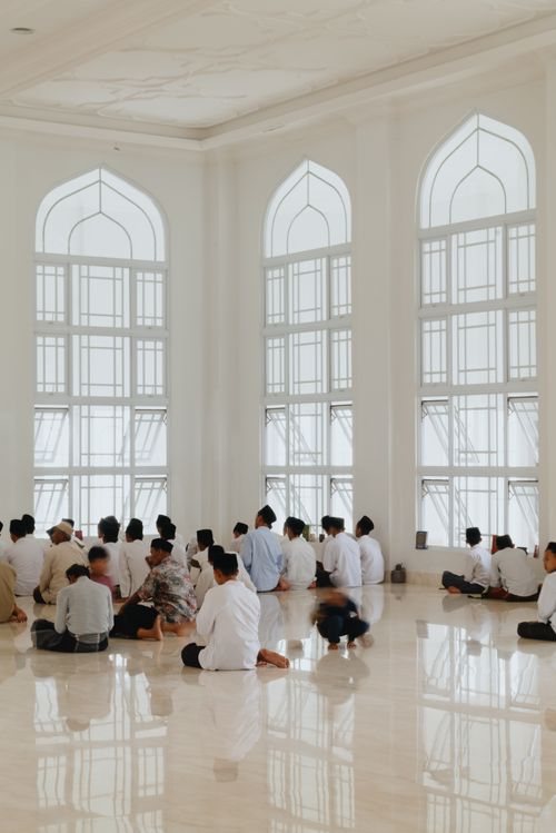 Free A peaceful scene of people gathered for prayer inside a bright white mosque in West Java, Indonesia. Stock Photo