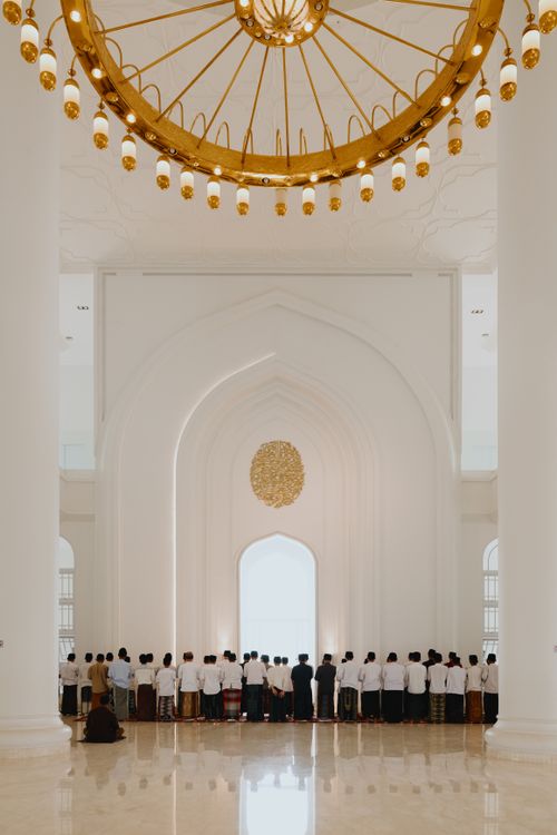 Free Muslim worshippers gathered for prayer in a modern mosque with intricate architecture. Stock Photo