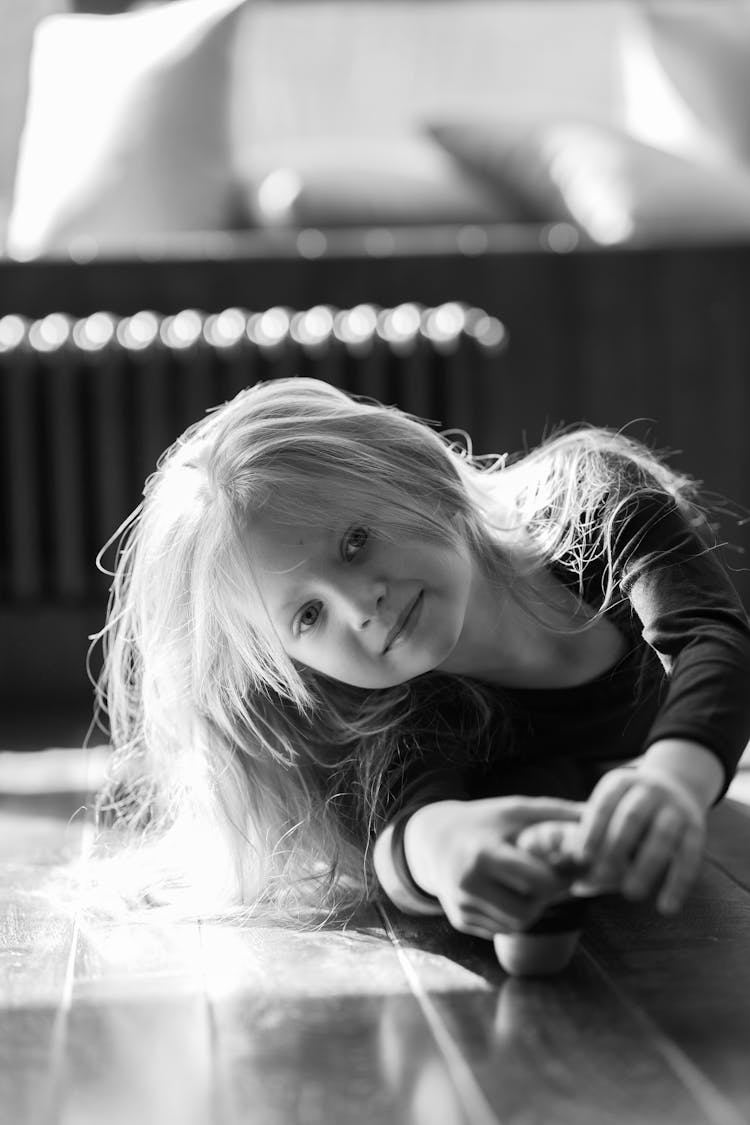 Smiling Little Girl Stretching On Parquet At Home