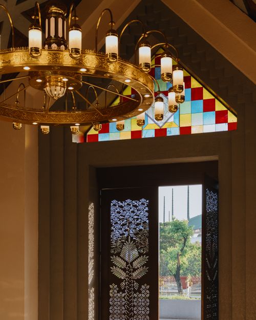 Free Ornate chandelier and stained glass window in Javanese architectural setting. Stock Photo