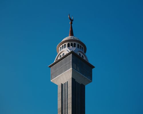 Free Detailed view of a mosque minaret with crescent, set against a clear blue sky in Jawa Barat, Indonesia. Stock Photo