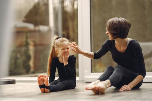 Free A mother and daughter bonding through yoga exercises, showcasing happiness and togetherness. Stock Photo