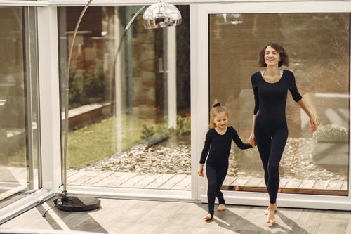 Free Happy mom and daughter in black outfits enjoying fun indoor time together. Stock Photo