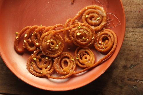 Free Golden spiral jalebis in a traditional clay plate garnished with pistachios. Stock Photo
