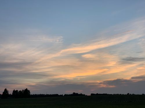 Free Beautiful sunset landscape over a rural field in Estonia, showcasing vivid sky colors. Stock Photo