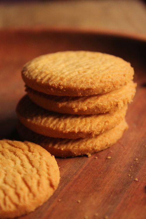 Free Close-up of a stack of golden homemade biscuits on a wooden surface. Stock Photo