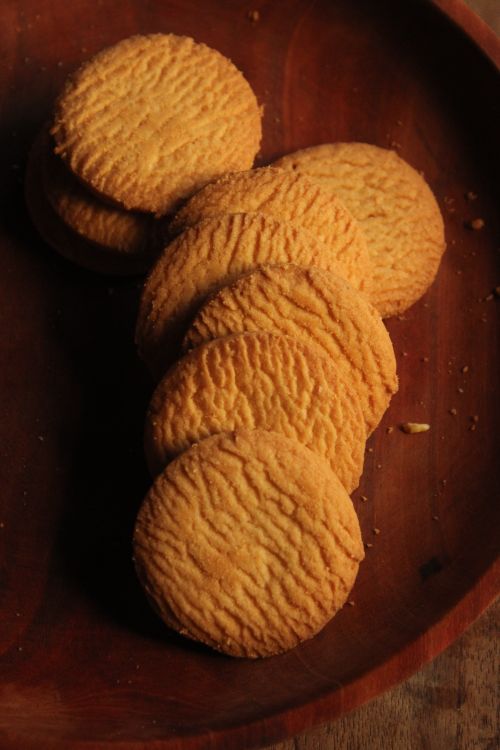 Free Delicious golden brown butter cookies set on a rustic wooden plate. Stock Photo