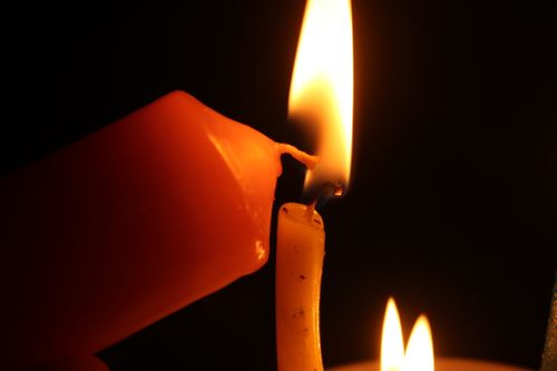 Free A close-up shot of two candles with flames emitting a warm, soft glow. Stock Photo