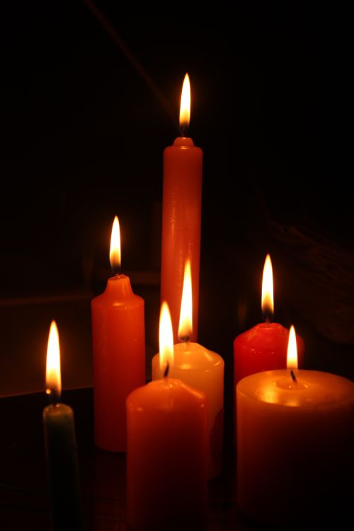 Free A serene arrangement of lit candles against a dark background creating warm ambiance. Stock Photo