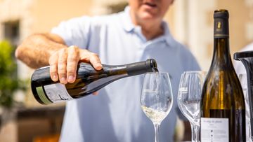 Vino blanco sirviéndose en dos copas