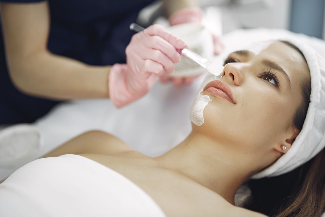 Close-up of a dermatologist examining a patient's skin at an aesthetic clinic