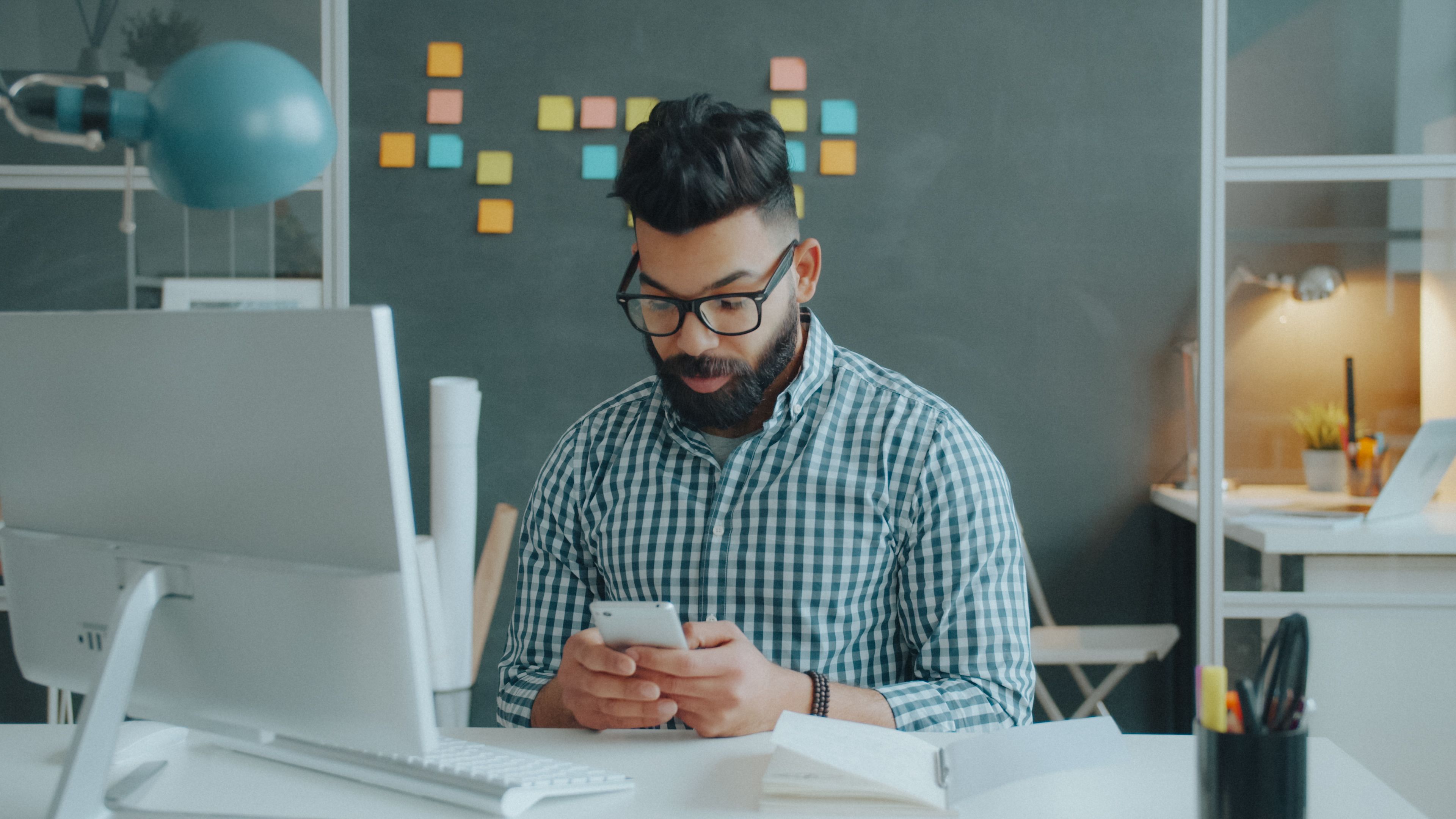 Homem sentado à mesa configurando um novo celular com o aplicativo do banco aberto.