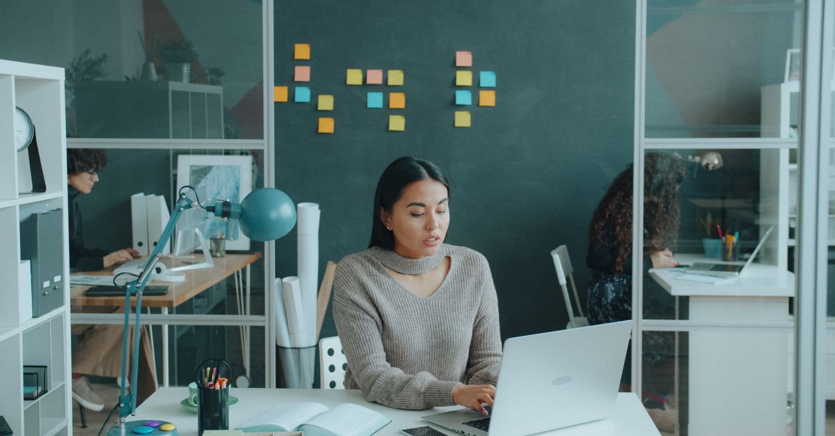 diverse team collaborating in modern office with AI dashboards on screens