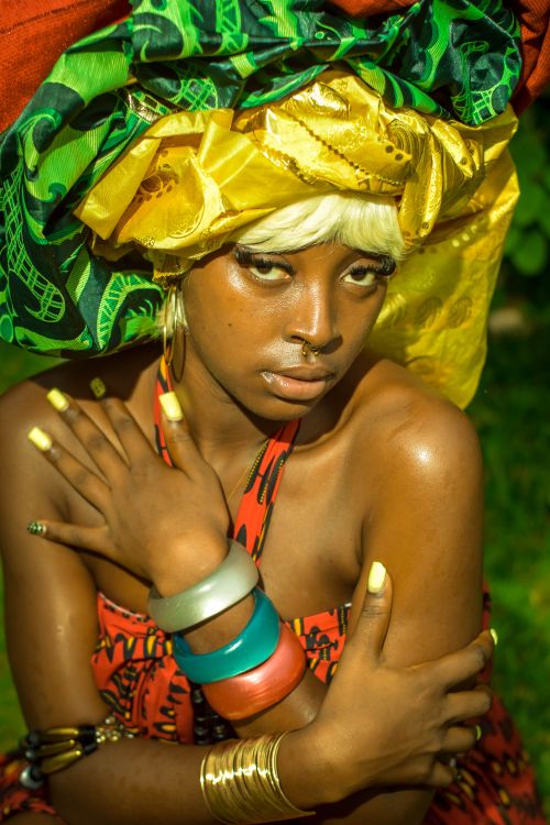 Free Captivating portrait of a woman adorned in a colorful African headwrap and accessories. Stock Photo