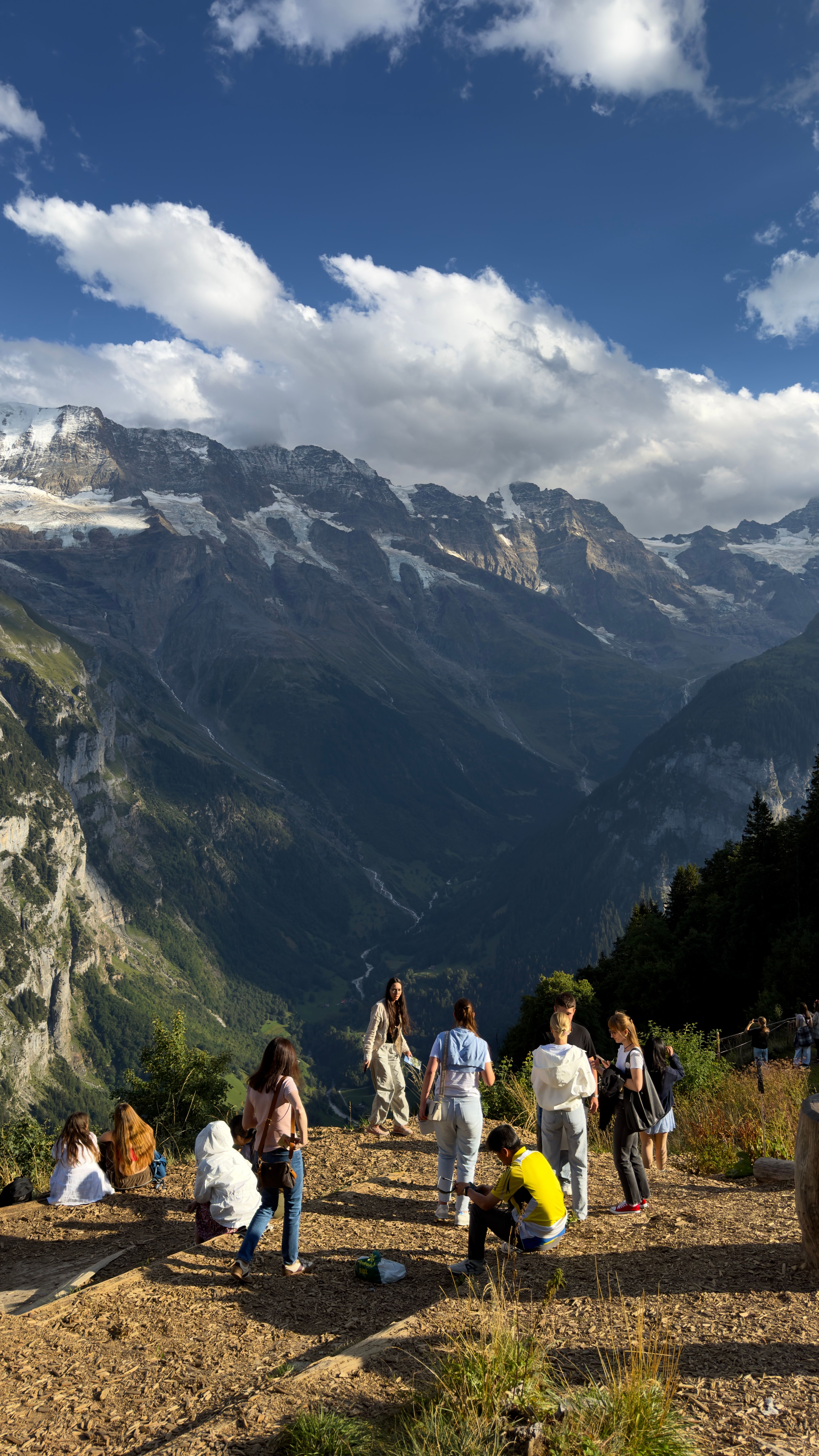 Fotomural Vista panorámica de turistas disfrutando del paisaje montañoso en Lauterbrunnen, Suiza.