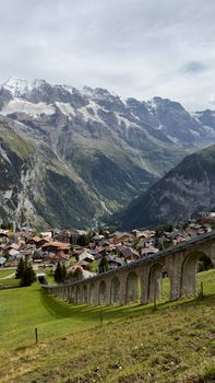 Scenic view of Lauterbrunnen, Switzerland featuring alpine village and viaduct under majestic mountains. - Fotografer Sidoarjo