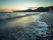 在加拿大不列颠哥伦比亚省的鹅卵石海岸线上，宁静的日落捕捉了海岸的宁静之美