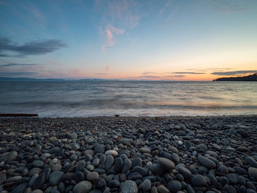 日落期間在海邊的石頭