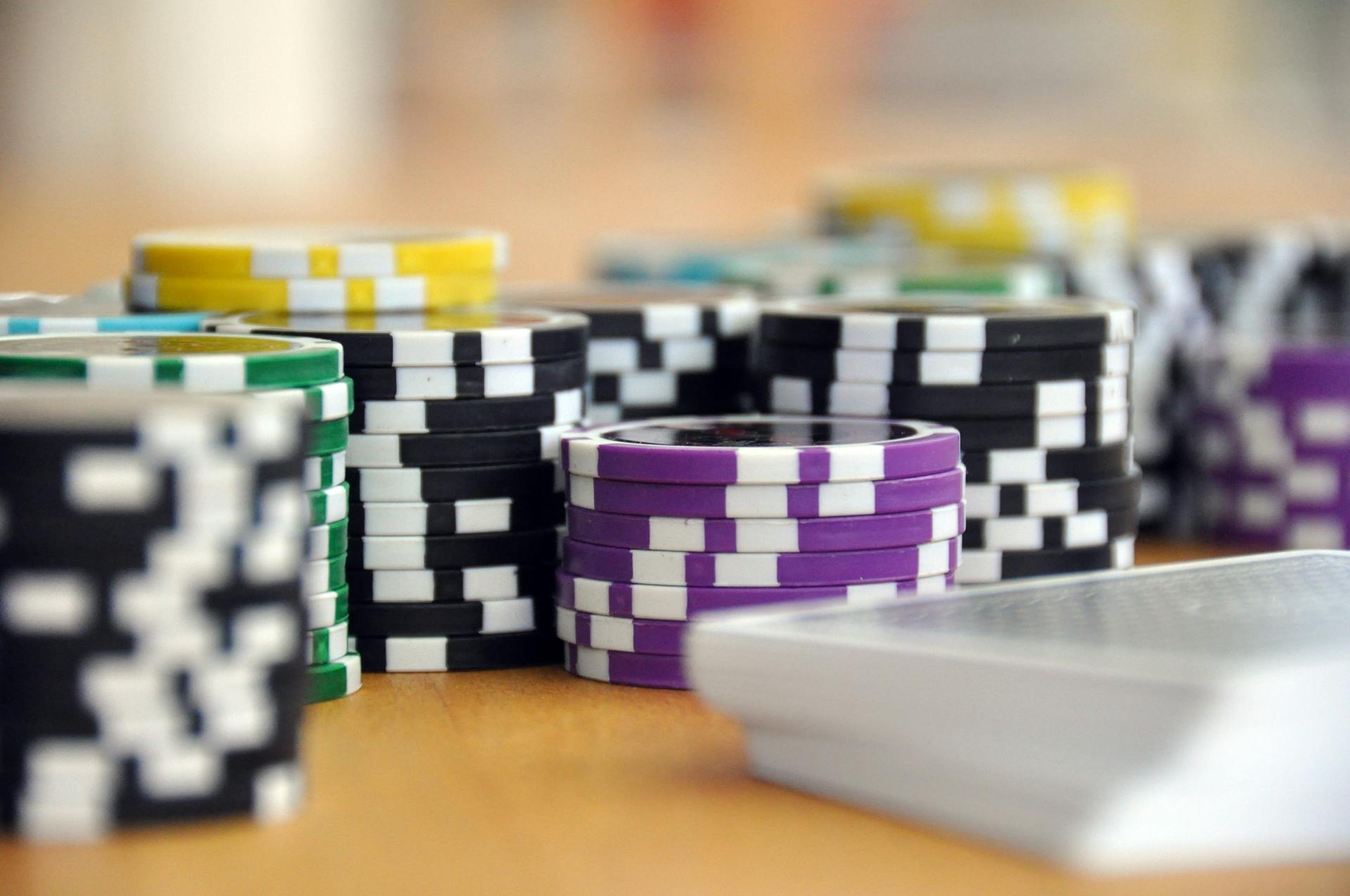 A close-up shot of stacked poker chips and playing cards on a table, perfect for casino and gambling themes.