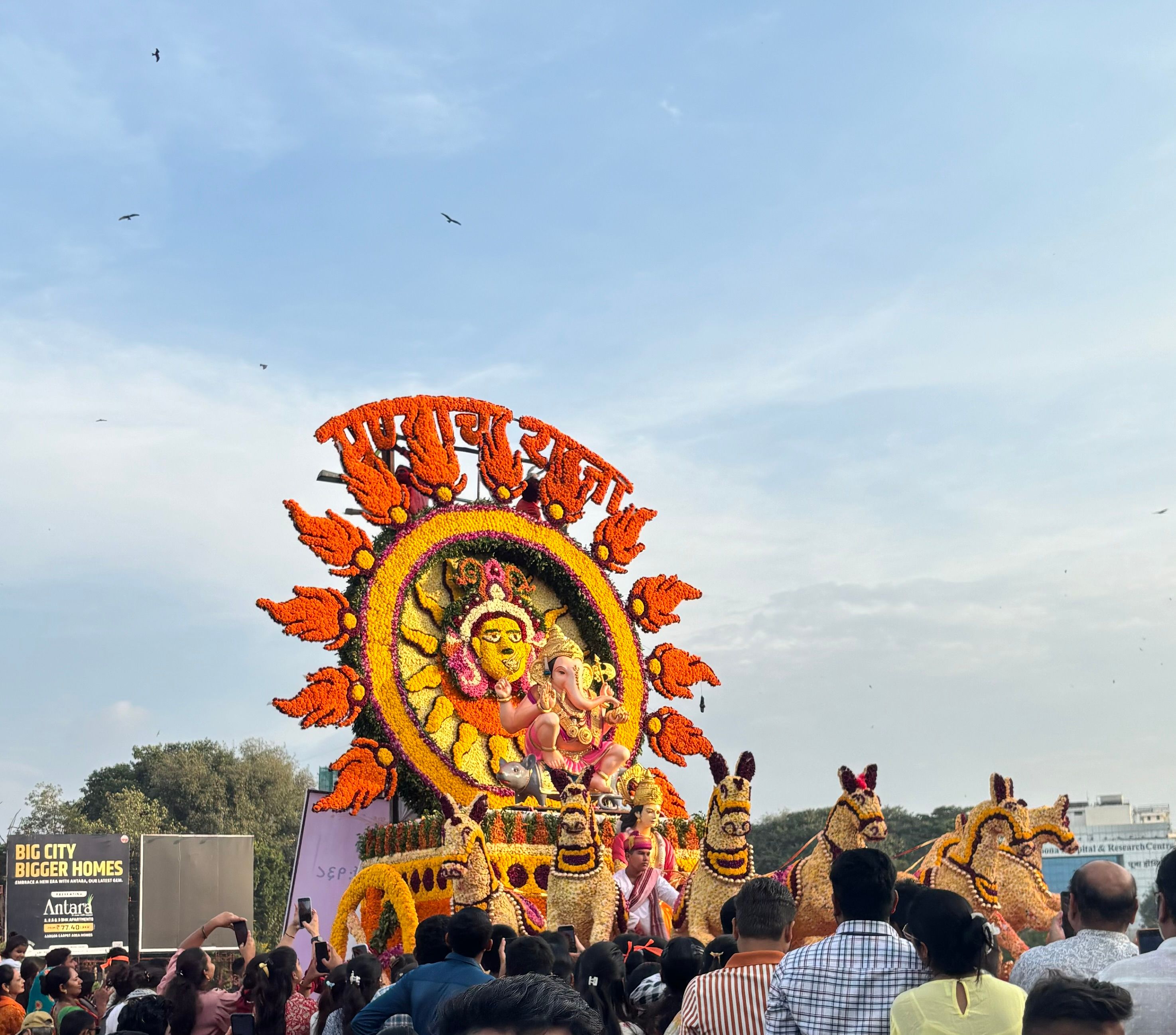 Vibrant Ganesh festival parade in Pune with decorative chariot and large crowd.