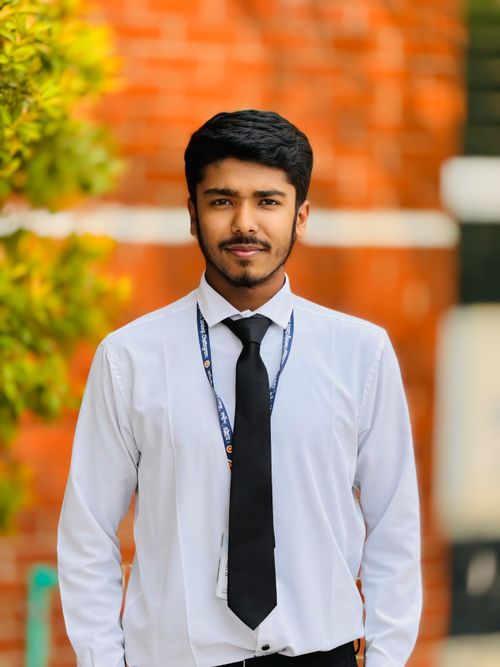 Free Young man in a white shirt and tie, confidently posing outdoors with a vibrant background. Stock Photo