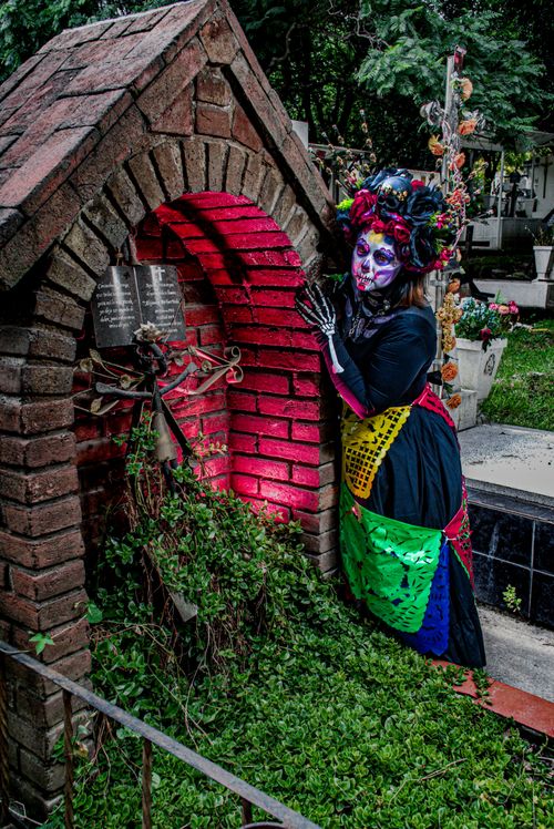 Free A colorful Day of the Dead figure in vibrant costume at a cemetery, showcasing festive cultural traditions. Stock Photo