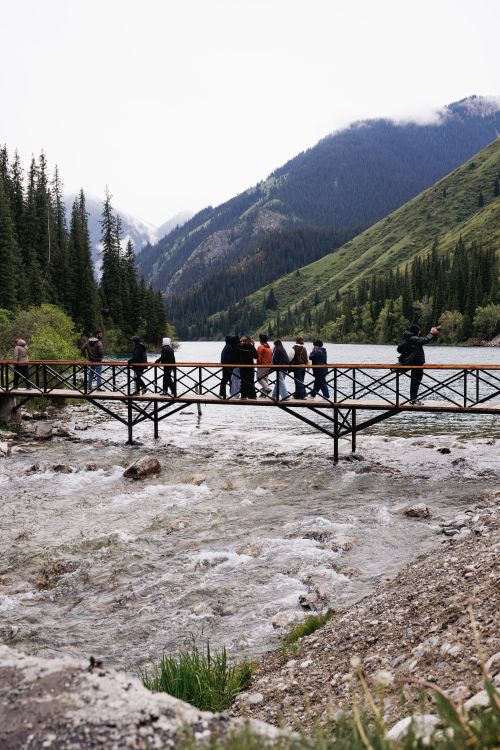 Free Group of people on a bridge with scenic mountain views in Almaty, Kazakhstan. Stock Photo