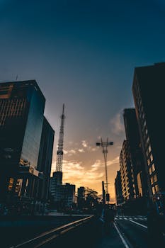 城市建筑物和塔楼的剪影，映衬在充满活力的日落天空下