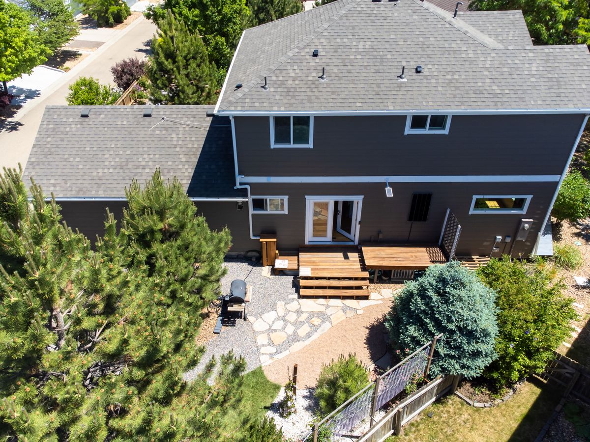 Aerial view of a suburban backyard with a wooden patio and landscaped garden
