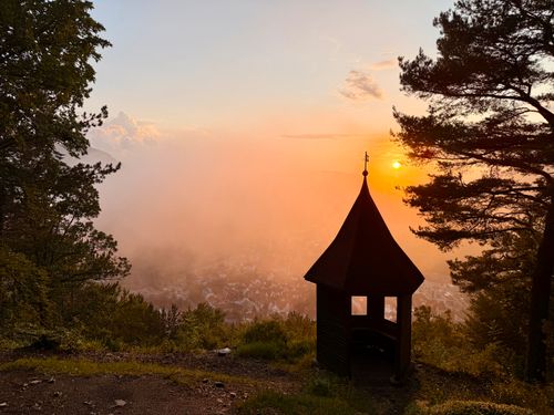 Free Captivating sunset view from a hilltop pavilion in Bad Urach, Germany, surrounded by lush trees. Stock Photo