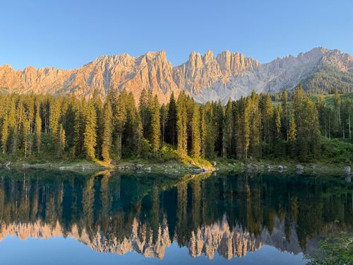 Free Stunning sunrise view of Karersee in Trentino-Südtirol with mountain reflection. Stock Photo