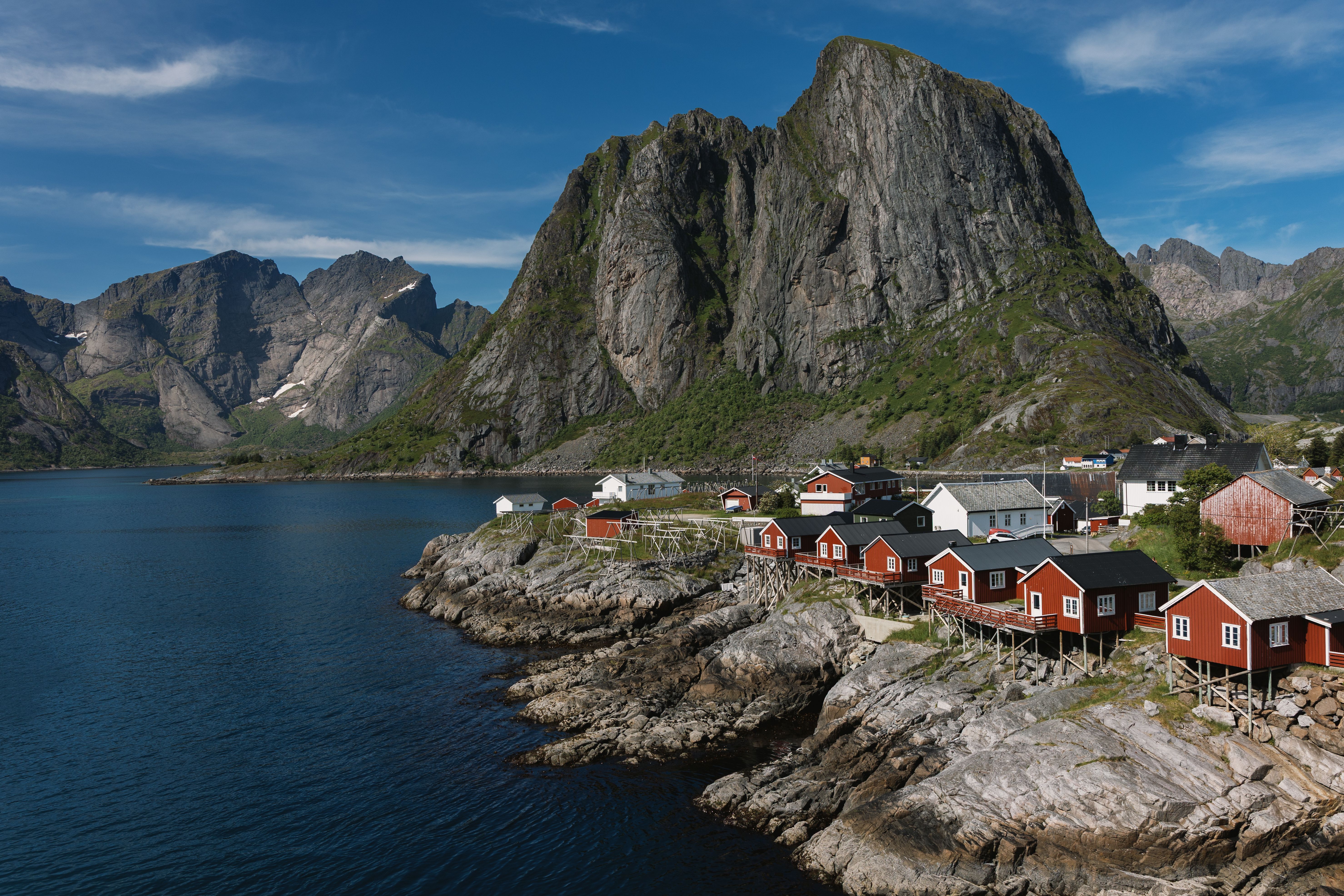 Stunning view of Lofoten Islands' coastline with red cabins and majestic mountains.