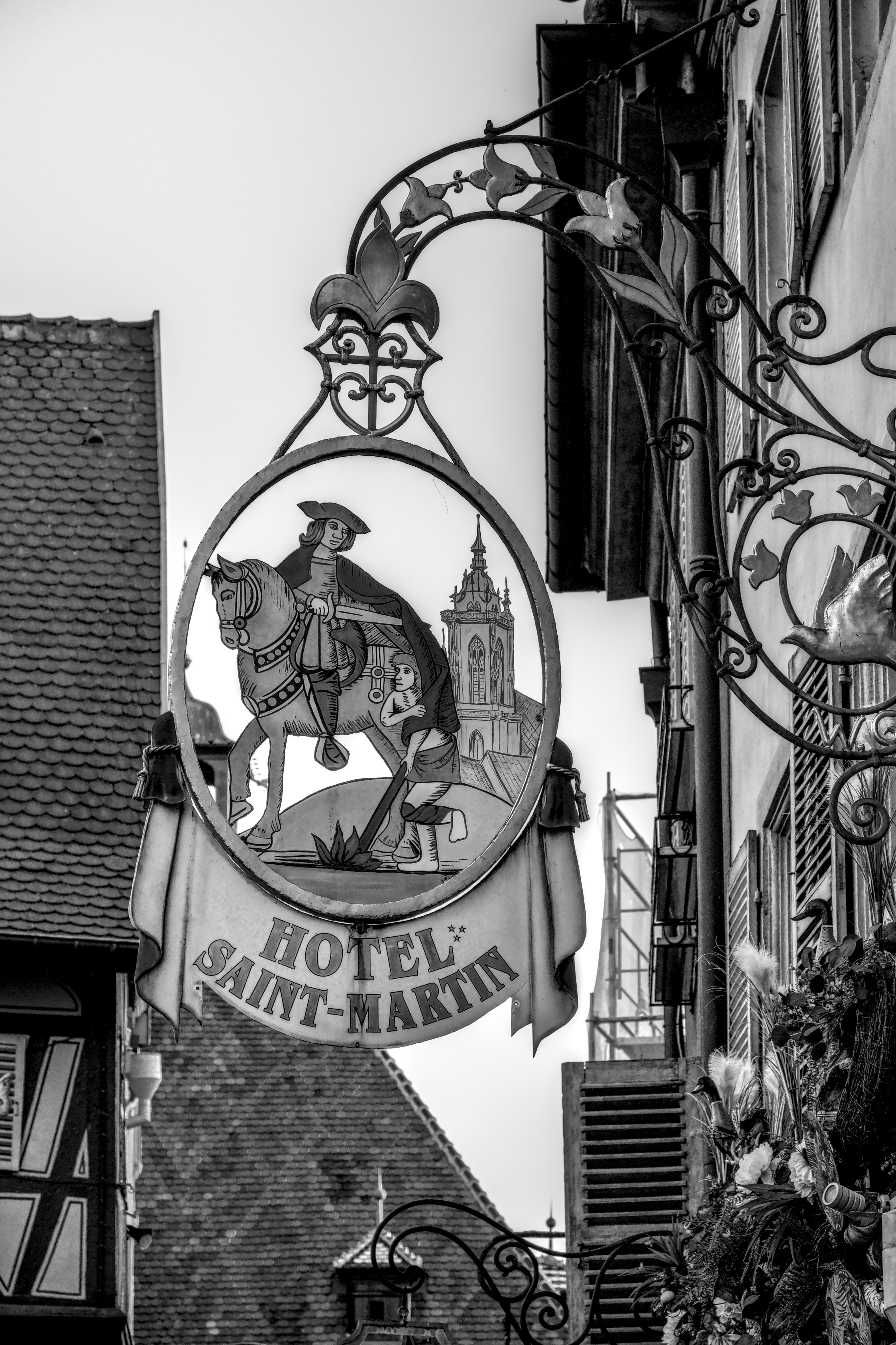 Black and white image of a historic hotel sign in Colmar, France.