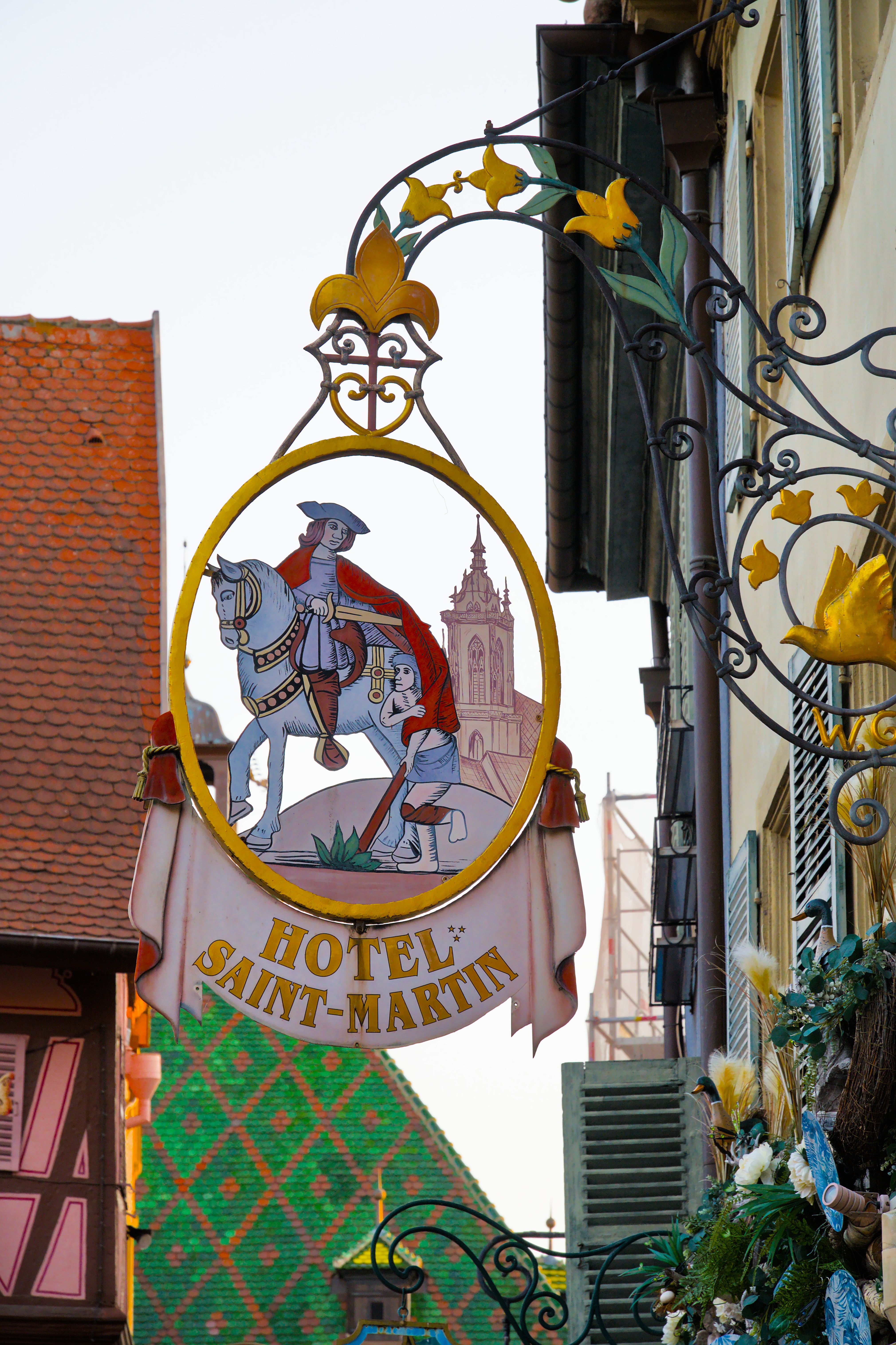 Colorful traditional sign of Hotel Saint Martin in Colmar, showcasing classic French architecture.