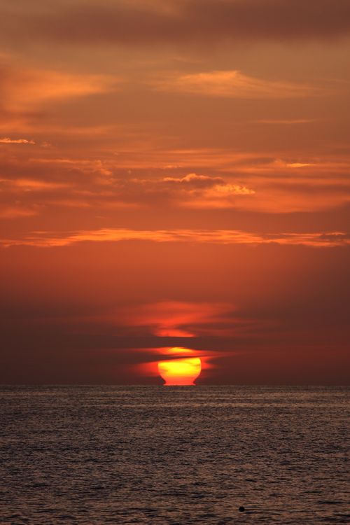 Free Stunning ocean sunset with vibrant orange hues and dramatic sky, perfect for serene moments. Stock Photo