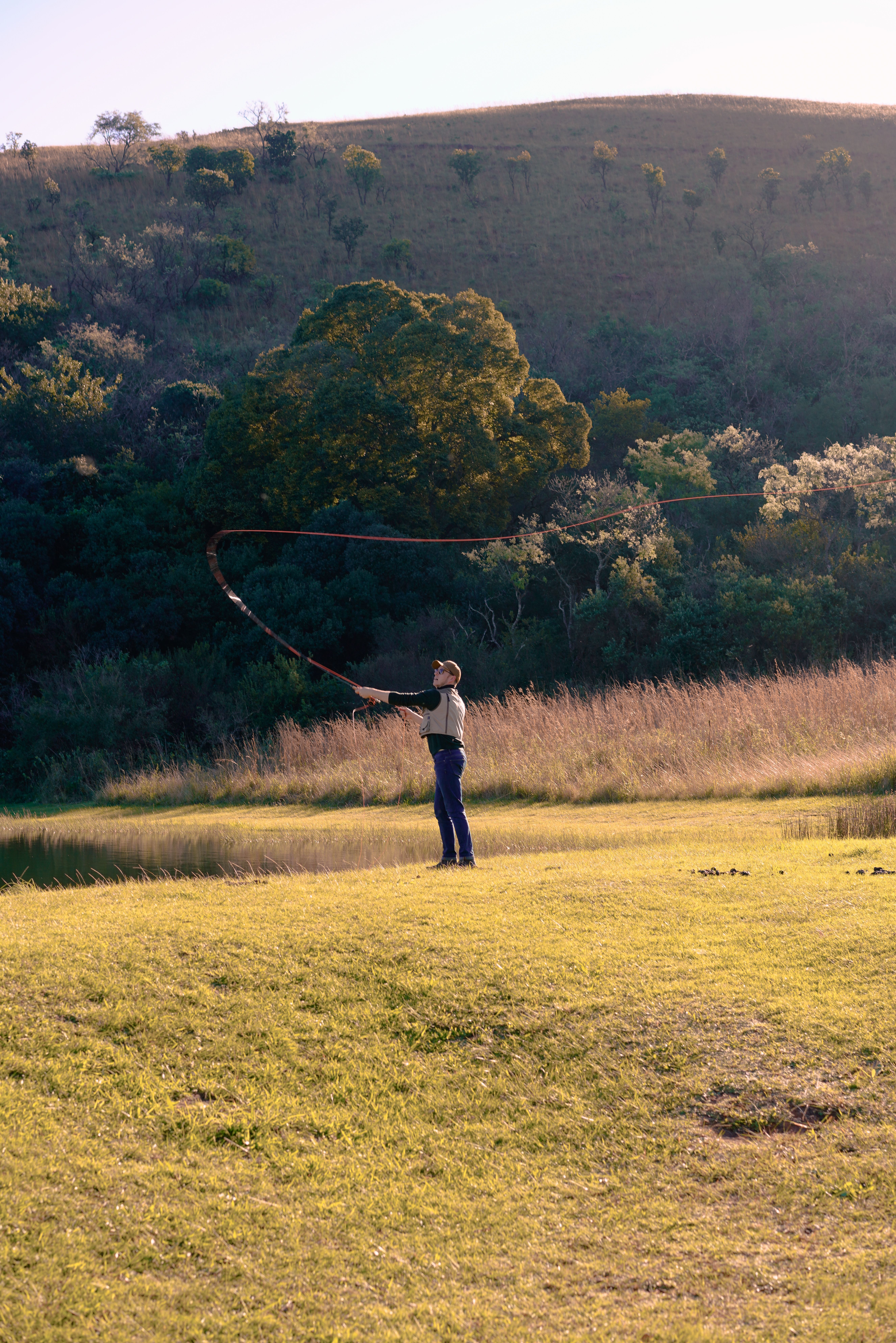Free Individual with whip against sunset landscape in Dullstroom, South Africa. Stock Photo